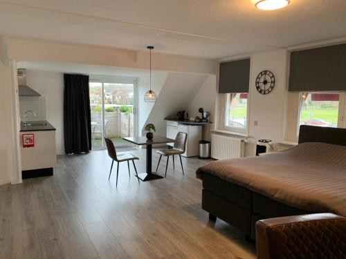 a bedroom with a bed and a table and chairs at Slapen bij de Buurvrouw in Castricum