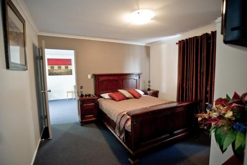 a bedroom with a bed with red pillows on it at Centrepoint Motor Inn in Rockhampton