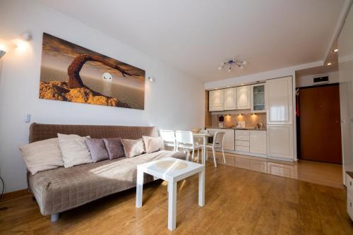 - un salon avec un canapé et une table dans l'établissement Victus Apartamenty, Apartament Liczi, à Sopot