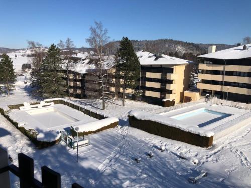 a snow covered roof of a building with a swimming pool at Magnifique appartement pied des pistes in Métabief