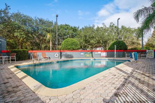 a swimming pool with blue water in a yard at Suburban Studios Orlando - Ocoee-Winter Garden in Orlando