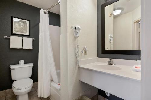 a bathroom with a toilet and a sink at Suburban Studios Orlando - Ocoee-Winter Garden in Orlando