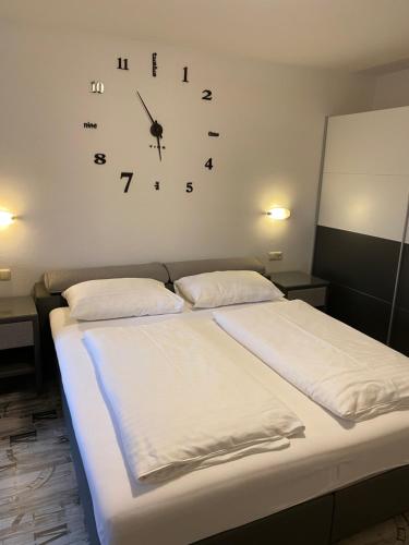 a bedroom with a bed with a clock on the wall at Apartments Margarethenbad in Rangersdorf