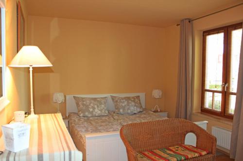 um quarto com uma cama com um candeeiro e uma cadeira em Ferienwohnung Abendsonne em Ostseebad Nienhagen