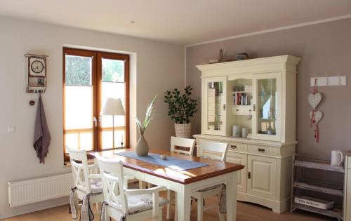 una sala da pranzo con tavolo e sedie bianche di Ferienwohnung Abendsonne a Ostseebad Nienhagen
