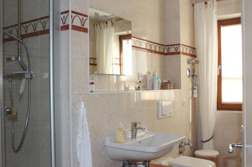 uma casa de banho com um lavatório, um chuveiro e um WC. em Ferienwohnung Abendsonne em Ostseebad Nienhagen