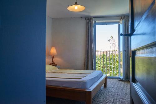 - une chambre avec un lit et une grande fenêtre dans l'établissement Jardin de Palme, à Lapalme