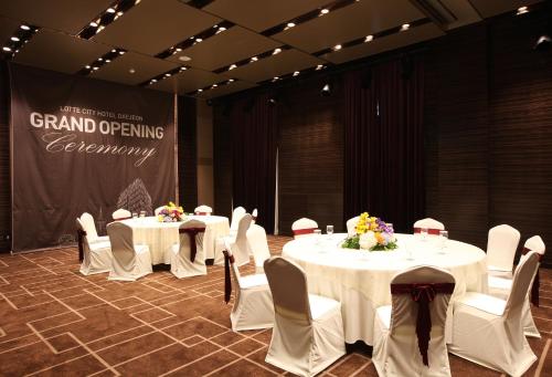 a room with two tables and chairs with flowers on them at LOTTE City Hotel Daejeon in Daejeon