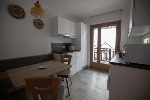 a small kitchen with a wooden table and a table and chairs at Villa Ula Verda- Apartments Marianna in Santa Cristina in Val Gardena