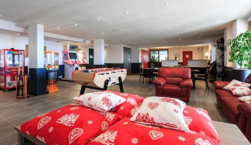 een woonkamer met rode banken en een pooltafel bij O - Sancy Résidence de Tourisme in Super Besse