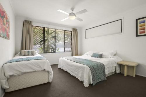 a bedroom with two beds and a window at Lakeshores 41 Coongarra in Kawana Waters