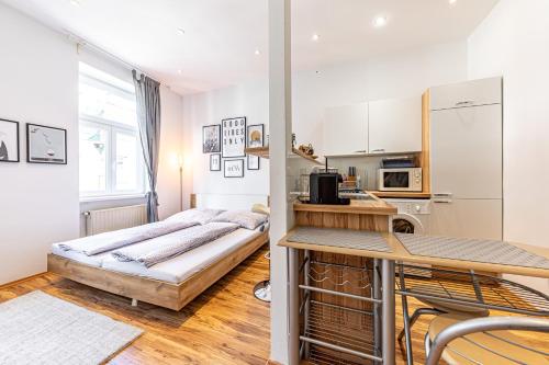um quarto com uma cama e uma cozinha com um frigorífico em COZY + TRENDY by JR City Apartments em Viena