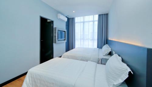 niebieska sypialnia z 2 łóżkami i oknem w obiekcie My Dream Hotel w mieście Kampong Ayer