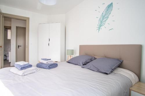 - un grand lit blanc avec des serviettes dans l'établissement Danton Renaissance - F2 rénové - Tout équipé, au Havre