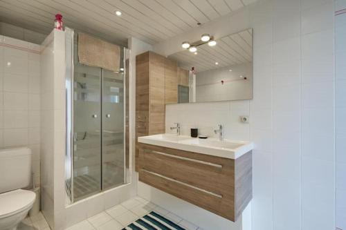a bathroom with a toilet and a sink and a shower at Zeesymfonie Oostduinkerke in Koksijde
