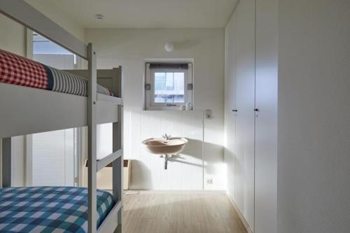 a bedroom with a bunk bed and a sink at Zeesymfonie Oostduinkerke in Koksijde