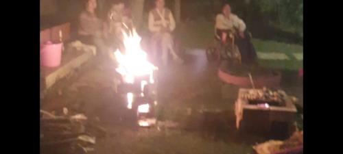 a group of people standing around a fire at Gardenia 29 in Raichak