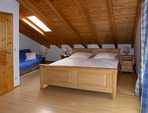 a bedroom with a large bed and a wooden ceiling at Haus Hornsteiner Barbara in Mittenwald