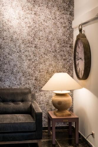 a living room with a couch and a table with a lamp at Een prachtige en luxueuze vakantiewoning dat is Hof Leskensdaele in Geraardsbergen