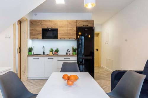 a kitchen with a table with oranges on it at TatryTop Apartamenty Alpejski SPA in Kościelisko