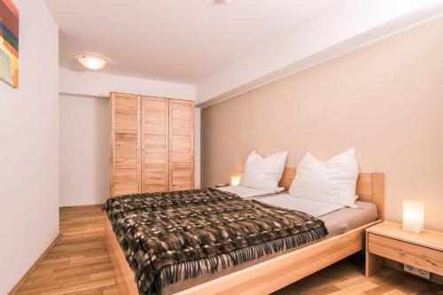 a bedroom with a bed with white walls and wooden floors at Obertauern Alps 4-Zimmer Appartement - Top 6 in Obertauern