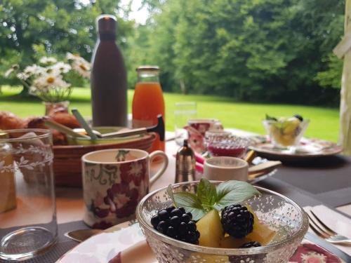 een tafel met een bord eten en een fruitschaal bij Bergerie de la Moutonnière in Le Pin