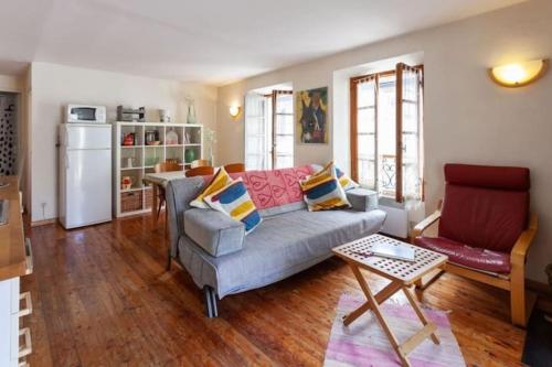 een woonkamer met een bank en een tafel bij Sunny 1-Bed apartment in lovely mountain village in La Brigue