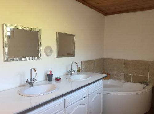 uma casa de banho com 2 lavatórios e uma banheira em Madeleine Rose em Cilaos