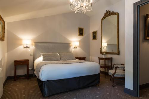 - une chambre d'hôtel avec un lit et un miroir dans l'établissement Le Logis du Péré, à Saint-Coutant-le-Grand