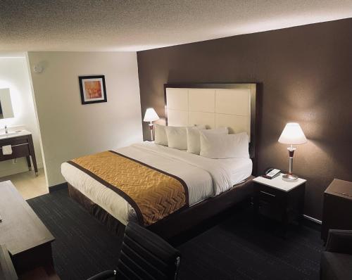 a hotel room with a large bed and two lamps at Wyndham Garden Detroit Metro Airport in Romulus