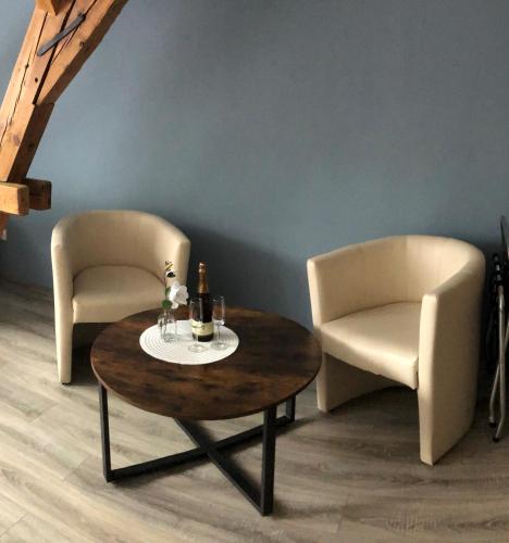 two chairs and a table with a bottle of wine at Altstadt-Residenz Manz in Wachenheim an der Weinstraße