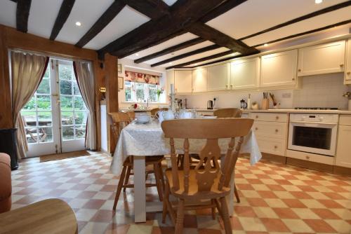uma cozinha com mesa e cadeiras num quarto em Whitefriars em Rye