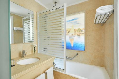 y baño con lavabo, bañera y espejo. en Steigenberger Resort Achti en Luxor