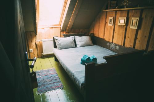 a small bed in a room with a window at Viesu nams Melnsils in Melnsils