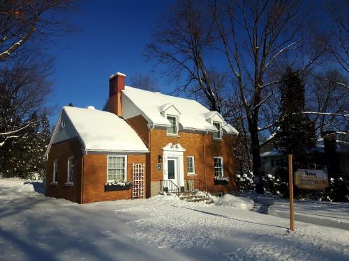 a brick house with snow on the ground at Gîte La Belle Aventure B&B in Grand-Mère