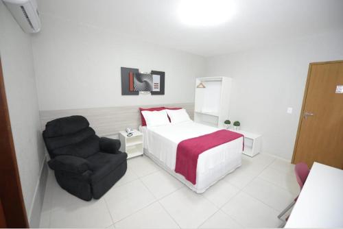 een hotelkamer met een bed en een stoel bij Hotel Leon in Barbalha