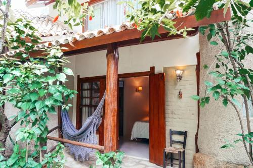 a patio with a hammock outside of a house at Pousada Fruta Pão in Barra Grande