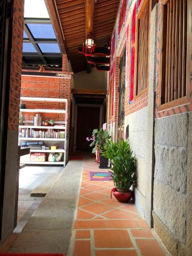 a hallway of a brick building with a potted plant at 金門后倉七號新古厝民宿 in Jinning