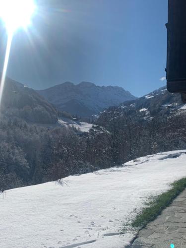 a snow covered hill with the sun in the background at Le 30 in Troistorrents