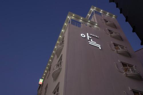 テジョンにあるAank Hotel Daejeon Yongjeon 1の時計付きの高層ビル