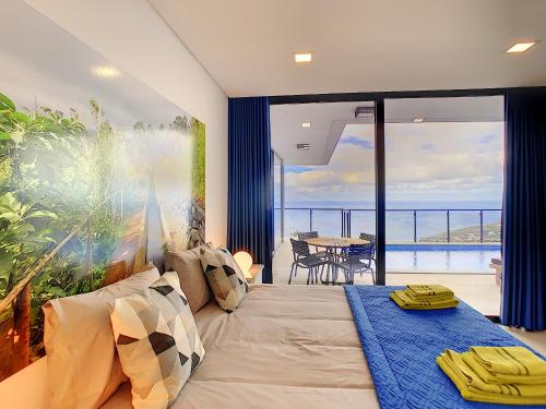 a bedroom with a bed and a view of the ocean at Casa Allegra by LovelyStay in Arco da Calheta
