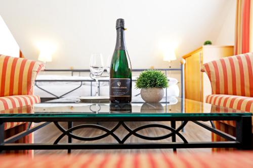 una botella de vino sentada en una mesa de cristal en Landhotel Altes Wasserwerk GbR, en Freinsheim