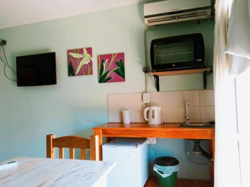 a kitchen with a table and a desk with a microwave at Hotel Are Pora in Gualeguaychú