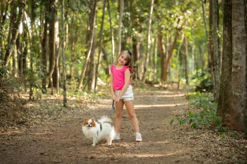 a little girl walking a dog on a dirt road at Canzi Cataratas Hotel in Foz do Iguaçu