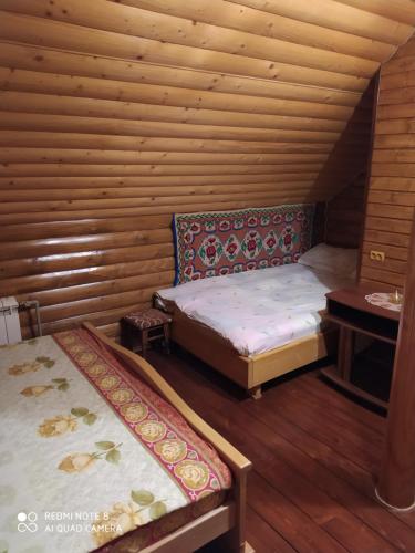 イズキにあるSadyba Gostynniy Dvirの木造キャビン内のベッド2台が備わる部屋