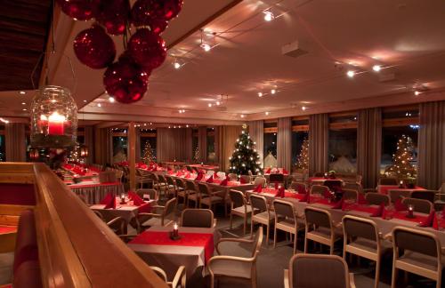 a restaurant with christmas decorations and tables and chairs at Hotelli Jussan Tupa in Enontekiö