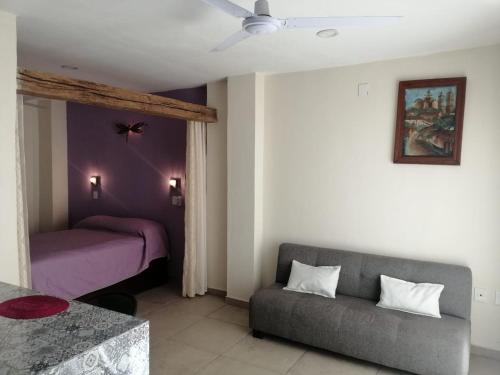 a living room with a couch and a bed at Aguacate Suites in Mazatlán