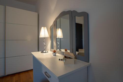 een badkamer met een wastafel met een spiegel en een lamp bij Villa Dada i Dida in Milna