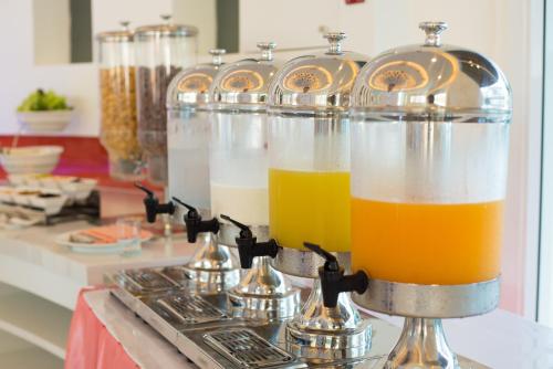 una fila di contenitori in vetro riempiti di succo d'arancia di The Beach Heights Resort SHA Plus a Kata Beach
