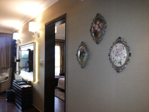 three mirrors on a wall in a living room at The Pllazio Hotel in Gurgaon